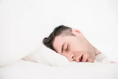man laying in bed, snoring