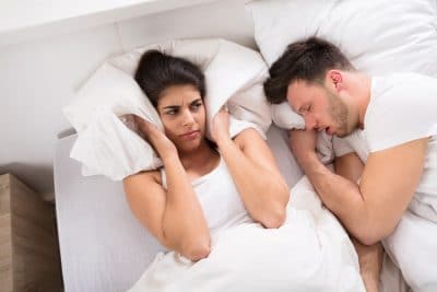 young adult woman irritated at snoring partner